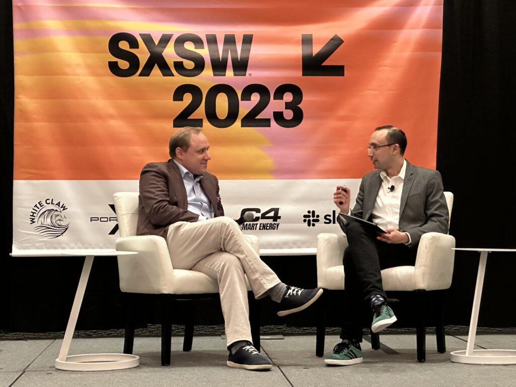 two people speaking on stage at SXSW 2023